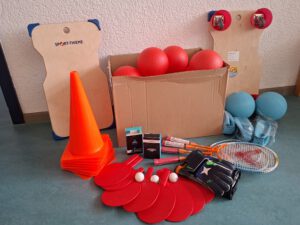 Bälle, Tischtennisschläger, Pilonen, ein Rollbrett, Torwarthandschuhe und diverse Schläger