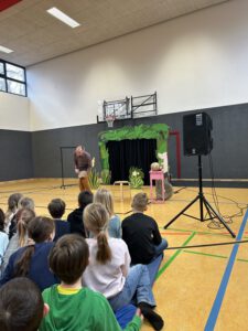 Peter Frenke spielt: Das verflixte Käsebrot im Vordergurnd sieht man Hinterköpfe der zuschauenden Kinder.